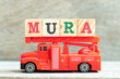 Fire ladder truck hold letter block in word mura on wood background