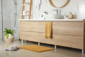 Wall Mural - Soft orange bath mat and slippers on floor in bathroom