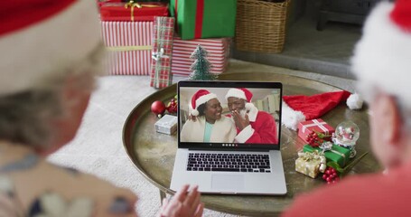 Sticker - Senior caucasian couple with santa hats using laptop for christmas video call with couple on screen