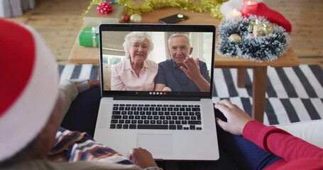 Poster - African american mother and daughter using laptop for christmas video call with couple on screen