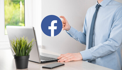 Onok,Ukraine - July 14,2021:Businessman holds, clicks, Facebook icon in his hands.Social network.global network and data customer connection.international network.