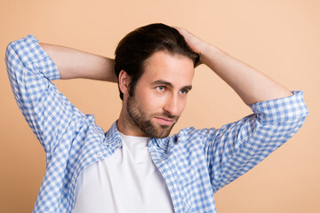 Sticker - Photo of cool young guy touch hair look empty space wear plaid shirt isolated on beige color background