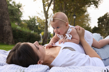 Canvas Print - Happy mother with adorable baby lying in park