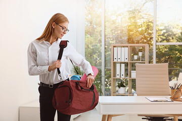 Poster - Beautiful businesswoman with sports bag in office