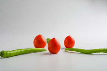 Wall Mural - Fresh Green chilli and tomatos on white background.