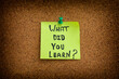 A sticky note with the question what did you learn written on it. Close up.