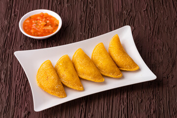 Wall Mural - Fried empanadas with spicy sauce - Typical Colombian food