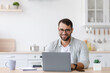 © Prostock-studio - Smiling mature caucasian male manager or student with beard in glasses work at laptop