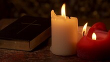 Bible / Christian Hymnbook And Candlelight On A Vintage Table. Prayer Light. Christmas, Advent Or Other Religious Season.