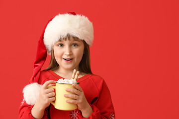 Wall Mural - Little girl with cup of hot cocoa on color background