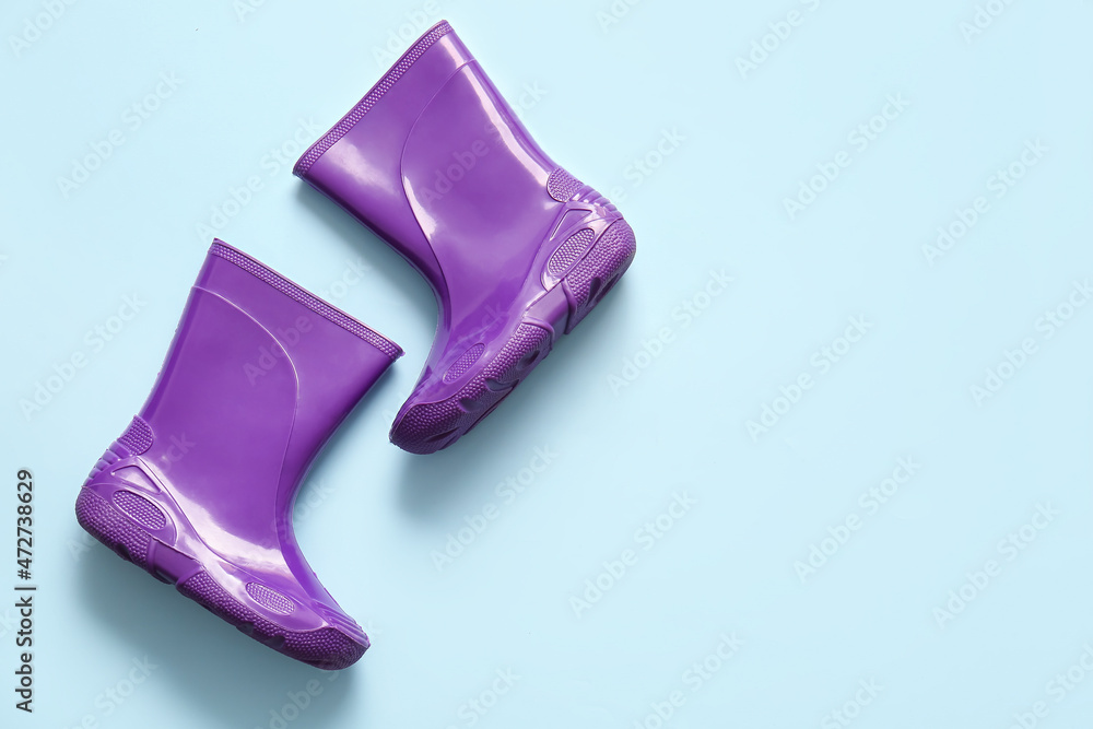 Pair of rubber boots on blue background
