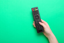 Woman Holding TV Remote Controller On Green  Background
