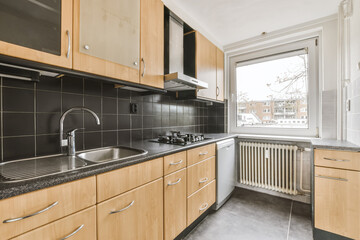 A breathtaking kitchen with wood kitchen unit and black backsplash