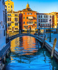 Wall Mural - Colorful small canal and bridge Grand Canal creating beautiful reflection in Venice, Italy.