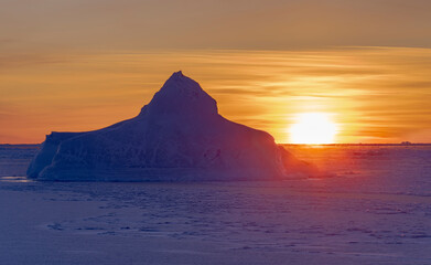 Wall Mural - Sunset at the shore of frozen Disko Bay during winter, West Greenland, Denmark