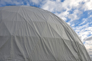 tent with hemispherical structure with triangle support frame. The white plastic is made of white plastic tarpaulin. The casing has holes for entry inside. research facility with its own atmosphere
