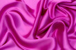 Close-up texture of natural red or pink or fuchsia fabric or cloth in same color. Fabric texture of natural cotton, silk or woo textile material. Red or pink or fuchsia fabric canvas background
