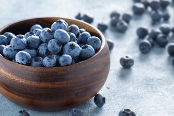 Fresh blueberries in wooden bowl with copy space close up