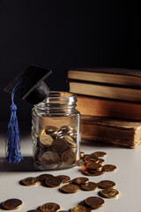 Savings for education concept. Coins in jar with graduation cap. Vertical image