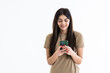 © dianagrytsku - Pleased brunette woman writing message on smartphone over white background