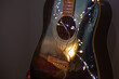 Acoustic guitar closeup with string light for Christmas. Music for winter evenings concept.