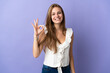 © luismolinero - Young caucasian woman over isolated background showing ok sign with fingers