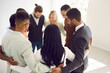 © Studio Romantic - Diverse team of happy business people hugging in office. Group of young multi ethnic mixed race businessmen and businesswomen standing together holding arms around each other. Teamwork, unity concept