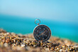 © yanadjan - Compass on the sea beach. Selective focus.