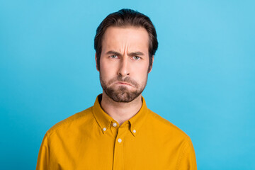 Wall Mural - Photo of sad young brunet guy offend wear yellow shirt isolated on blue color background