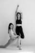 © kalinichenkod - Two sports girls posing isolated on a white background. Fitness model woman in studio with copy space