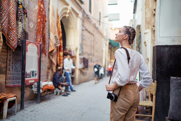 tourism and technology. happy young woman taking photo of marrakesh old town. traveling by morocco.