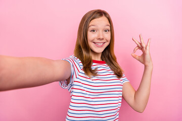 Sticker - Photo of cute small girl do selfie show okey wear red t-shirt isolated on pink color background