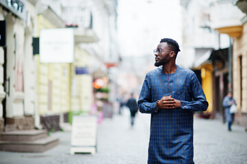 Wall Mural - African guy in blue authentic costume, eyeglasses. Fashionable nigerian man.