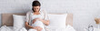 © LIGHTFIELD STUDIOS - pregnant young woman touching belly in bedroom, banner.