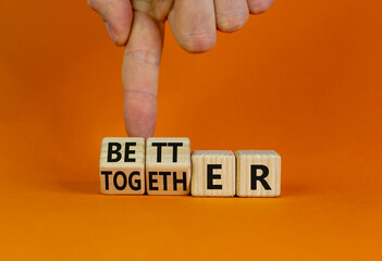 Wall Mural - Better together symbol. Businessman turns cubes and changes the word together to better. Beautiful orange table, orange background, copy space. Business, motivational and better together concept.