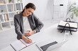 © LIGHTFIELD STUDIOS - cheerful pregnant businesswoman talking on smartphone and writing on notebook near laptop on desk.