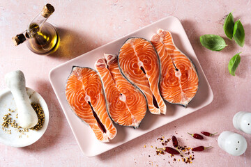 slices of fresh salmon in a pink plate on a pink table, ready to cook