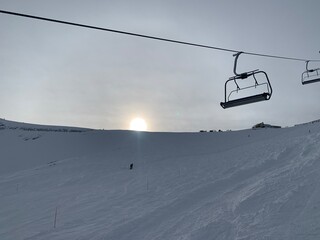 Wall Mural - ski lift in the mountains with setting sun