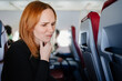 a cold woman coughs up a sore throat flying on an airplane. 