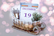 Calendar For December 19: Leaves Of A Calendar With The Name Of The Month, Number 19 In A Decorative Sleigh, A Fir Branch On A Light Background, Close-up