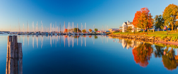 Wall Mural - USA, Wisconsin. Panoramic view of Fall colors reflected on the still waters of the harbor in Bayfield on Lake Superior.