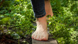 Closeup of barefoot woman walking on grass and wooden plank board in garden. Concept of freedom. loving nature and recreation