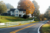 Fototapeta Na ścianę - Roadside farmhouse house in countryside rural road highway in West Virginia, USA by mountain forest with colorful autumn fall trees foliage at sunrise morning