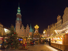 Wroclaw, Poland. Christmas Market On Market Square Close To Old Town Hall In Night. Figures Of Dwarfs, Which Are Symbols Of The City Of Wroclaw, Are Located In The Foreground.