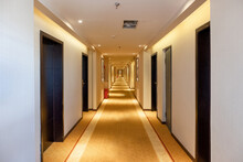 Hallway Straight With The Door And Golden Lighting Illuminated In The Hotel