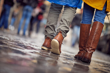 Wall Mural - Shot from below of a young couple in love who is walking the city on a rainy day. Walk, rain, city, relationship