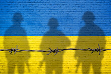 Flag Of Ukraine Painted On A Brick Wall With Soldiers Shadows. Relationship Between Ukraine And Russia