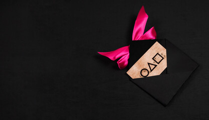 An invitation in a black envelope with a red bow on a black background from the game.