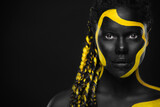 Fototapeta  - Yellow and black body paint. Woman with face art. Young girl with colorful bodypaint. An amazing afro american model with makeup.