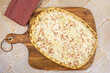 flammekueche (tarte flambée), spécialité alsacienne,  sur une planche à découper